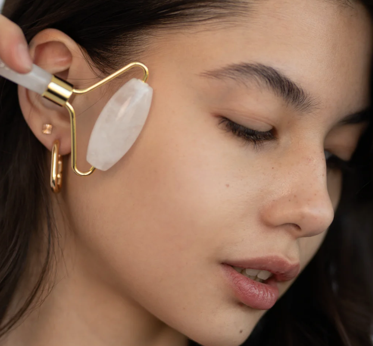 Woman using a facial roller on her face